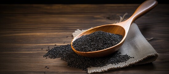 A copy space image showcasing black sesame seeds in a rustic wooden spoon on a tabletop