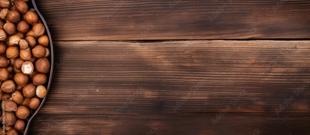 Poster A top down view of a spoon filled with shelled hazelnuts rests on a rustic wooden surface providing ample copy space for your textual needs