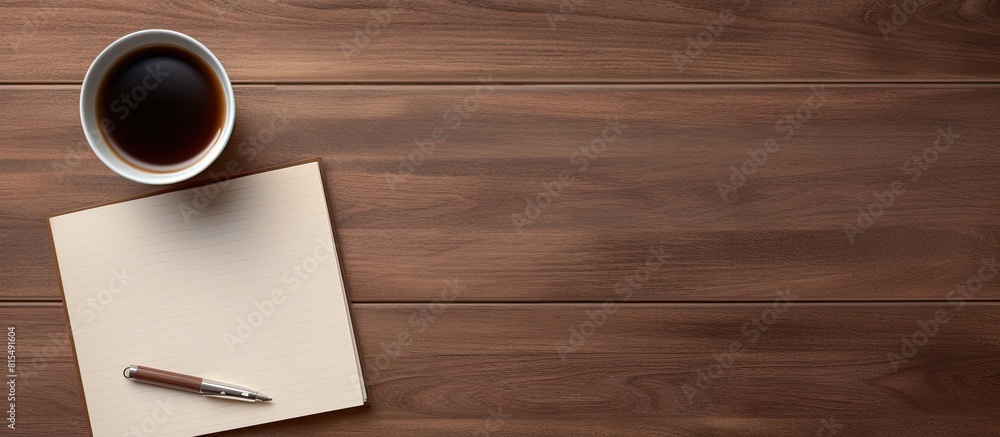 Poster Top view of a wooden office desk table with a blank notebook page a pen and a cup of coffee The image has copy space and is captured in a flat lay style