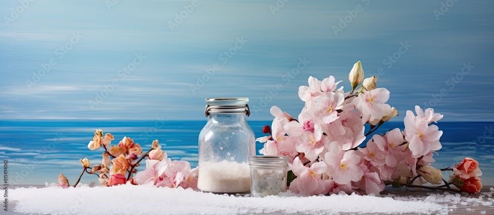Poster On the table there are three banks containing sea salt and flowers creating a copy space image