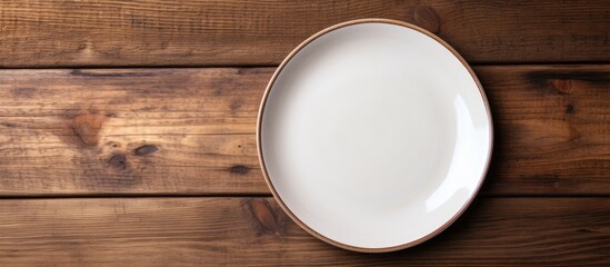 Top view of an empty plate displayed on a wooden surface with ample copy space for images