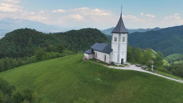 Catholic church of St. Primus and St. Felician at the top of the hill at Jamnik, Slovenia. Hiking, tourism concepts. Drone shot, 4K, 60FPS