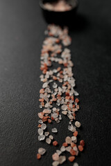 Colored Himalayan salt on a black background. Straight line Space for text