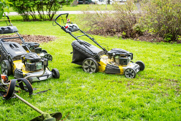 Lawn care, grass mowing, gasoline lawn mowers on grass.
