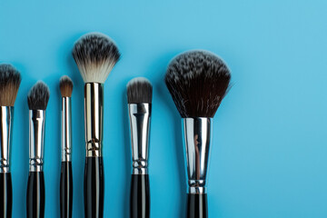 Set of professional makeup brushes on blue background