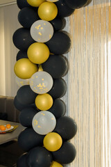 The decoration of the entrance to the holiday is made with balloons. A long string of gold and...