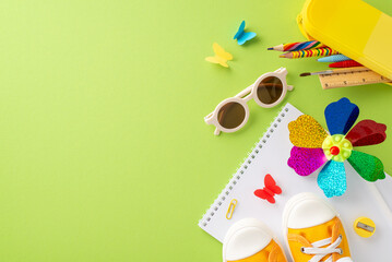 Preschool summer exploration theme. Top view of art tools - drawing album, colored pencils, sunglasses, sneakers, pinwheel, butterflies on soft green surface. Area for text or promo