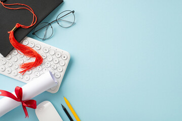 Online education completion theme. Overhead shot of keyboard, mouse, mortarboard, diploma, study...