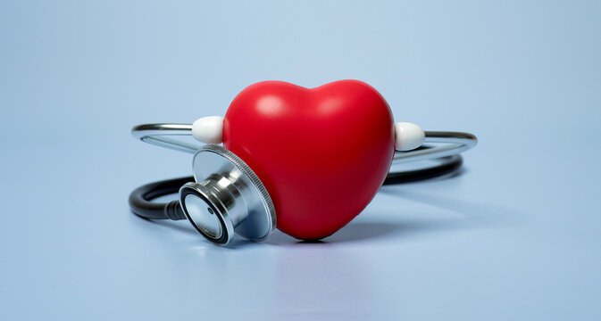 Red heart shape exercise ball with doctor physician's stethoscope on blue background, hospital life insurance concept, world heart health day. doctor day