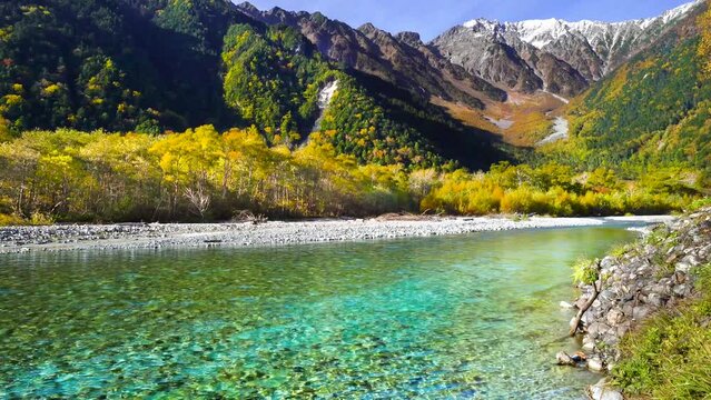 【長野県・松本市】紅葉が美しい秋の上高地　穂高連峰と梓川の風景　ティルトアップ　
Kamikochi with beautiful autumn leaves. Scenery of the Hotaka mountain range and the Azusa River - Nagano, Japan - 4K video - tilt up