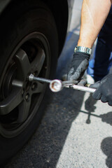 Auto mechanic changing tire on car on road close up