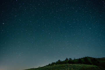 星空と山のシルエットが映える静かな夜景