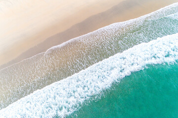 waves on the shore of a beach, turquoise sea waters. Aerial view with drone