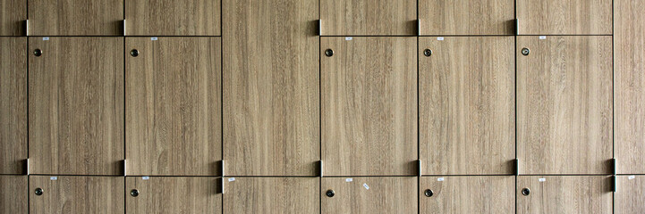 Wooden lockers with key in locker room at school sport club office.