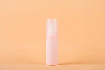 Cosmetic pink bottle, bottle, lotion or serum on cream background. 