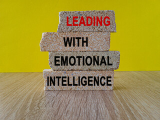 Leading with Emotional intelligence symbol. Concept words Leading with Emotional intelligence on brick blocks on a beautiful wooden table yellow background. Business concept.
