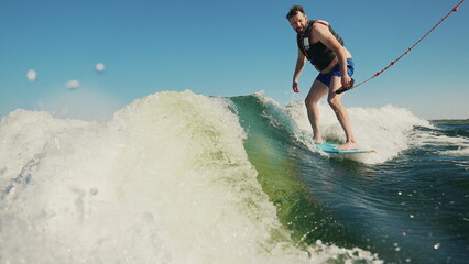 A man wakeboards after a boat. Fun on the water during the hot summer on the lake. Wakeboarding....