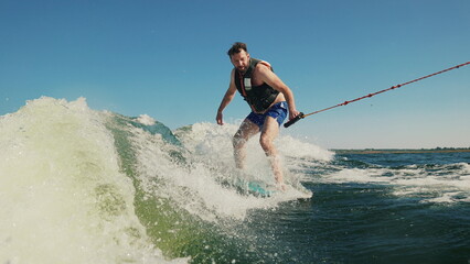 A man wakeboards after a boat. Fun on the water during the hot summer on the lake. Wakeboarding....