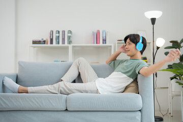 Young man relaxing with music on couch
