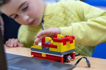 Boy building a robot in a robotics class for children