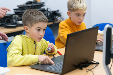 Two school-aged children in a robotics workshop