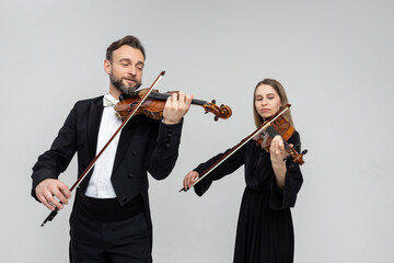 Man and woman fiddlers playing violin together