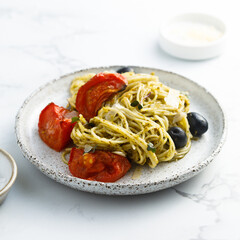 Spaghetti with pesto, tomatoes and olives