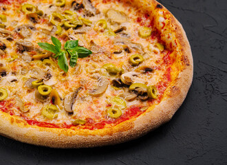 Freshly baked mushroom and olive pizza on black background