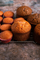 Small freshly baked cake and cupcakes in the background. Pastry table.