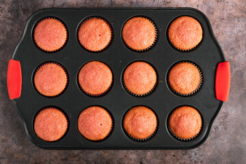 Cupcakes fresh from the oven on a tray. Top view.
