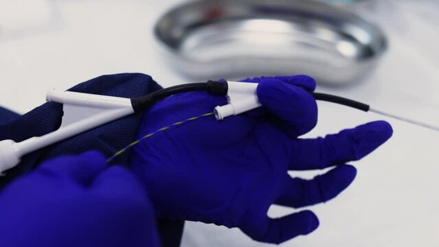 doctor with blue latex gloves preparing endoscopy equipment for procedure 60fps