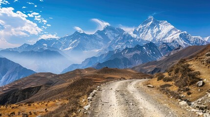 A dirt road winds through a high mountain pass in the Himalayas.