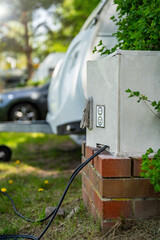 Electric camper - connecting the camper to the electricity - camping. Green Electricity - modern...