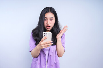 Surprised Young Woman Using Smartphone Isolated on Grey Background