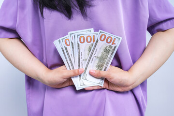 Businesswoman hiding bribe money behind her back. Corruption concept.