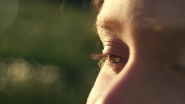 Close up of child face at sunset, beautiful blue eyes, portrait pretty little girl kid enjoying warm summer sunlight, outdoor relax, slow motion