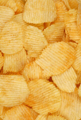 Crispy potato chips in macro. Golden fried potatoes close up. Potato snack for unhealthy fast food. 