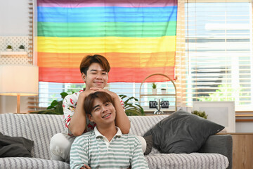 Romantic young gay couple resting together on the sofa at home. LGBTQ people lifestyle concept