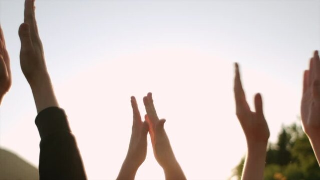 Close up of group people clapping hands at sunset. Family enjoying beautiful summer nature, greeting beautiful day. Slow motion