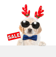 Funny Golden retriever puppy dressed like santa claus reindeer  Rudolf with tie bow and sunglasses...