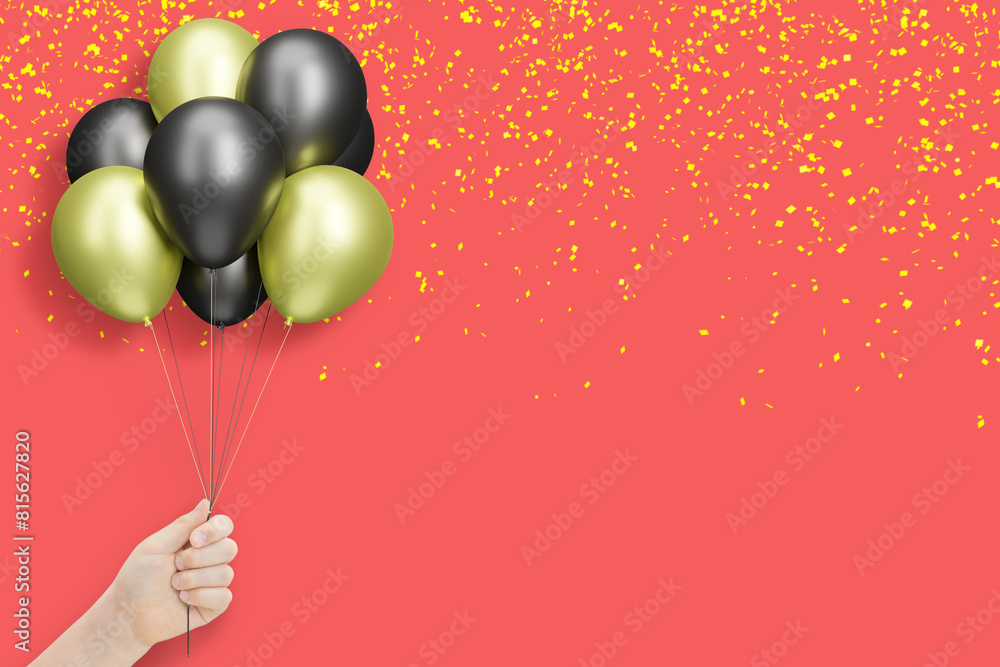 Poster female hand holding bunch of shiny golden and black balloons on red background with confetti. empty 