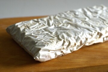 Raw Tempe or tempeh block on a wooden cutting board, traditional Indonesian food made of fermented soybean
