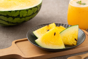 Fresh yellow watermelon juice in a glass cup on gray table background.