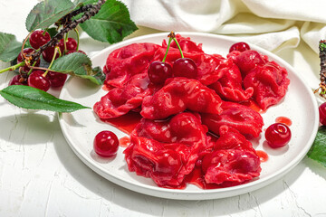 Dumplings, filled fresh cherries. Ripe fruits, sweet sauce, sour cream. Traditional Ukrainian dish