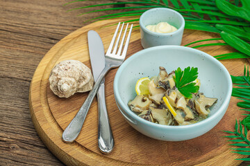 Rapana clam meat with oil, spices and greens. Healthy seafood is rich in omega. Marine decor