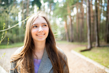 Portrait of a beautiful teenage girl, young woman with long hair in the park	