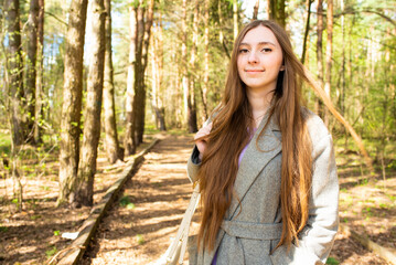 Naklejka premium Portrait of a beautiful teenage girl, young woman with long hair in the park 