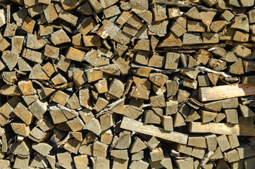 Stack of old chopped firewood, wooden background