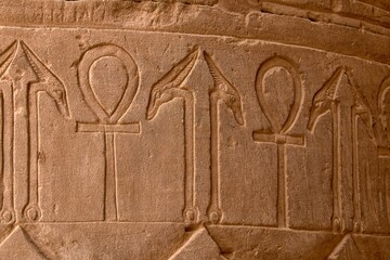 Egyptian hieroglyphs carved into the stone on the walls of the Edfu temple in Egypt.