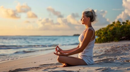 Senior woman doing yoga on the beach